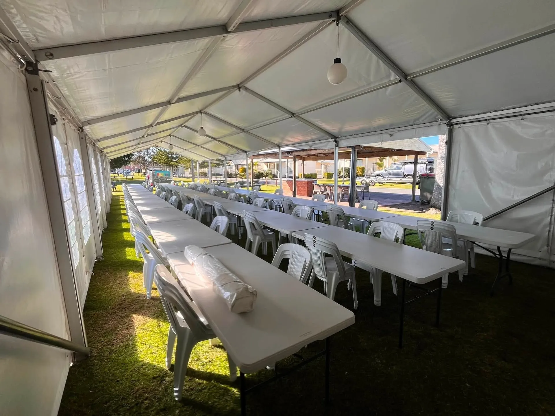 Wide view of a function space with trestle tables and chairs set for a function