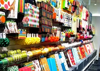 Shop shelving stacked with packaging supplies, wraps and rolls in store at Tuncurry