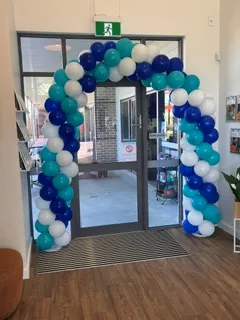 Blue, white and silver balloon arch framing a shop entrance