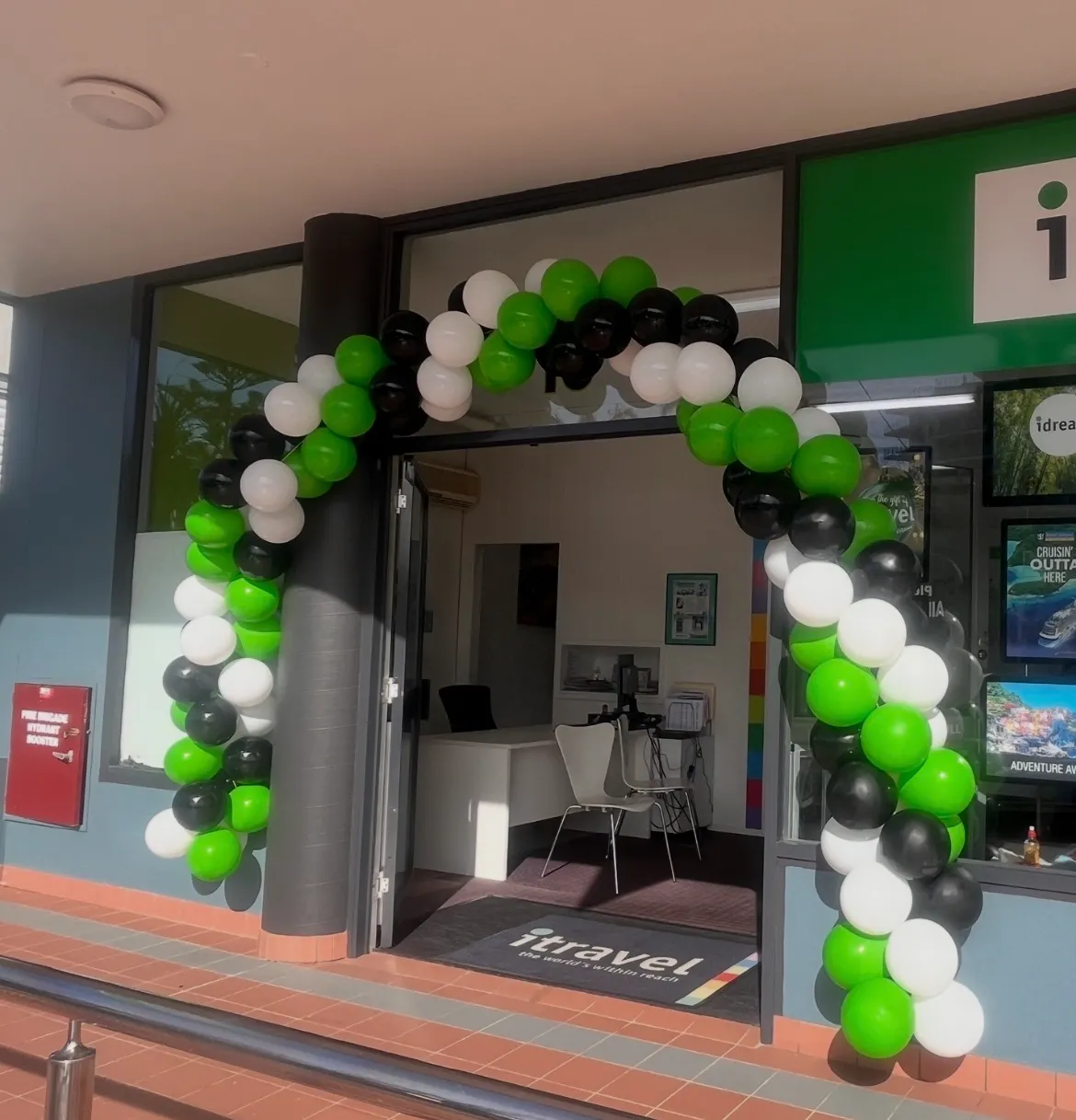 Green, black and white custom balloon garland arch around a shop entrance in Tuncurry