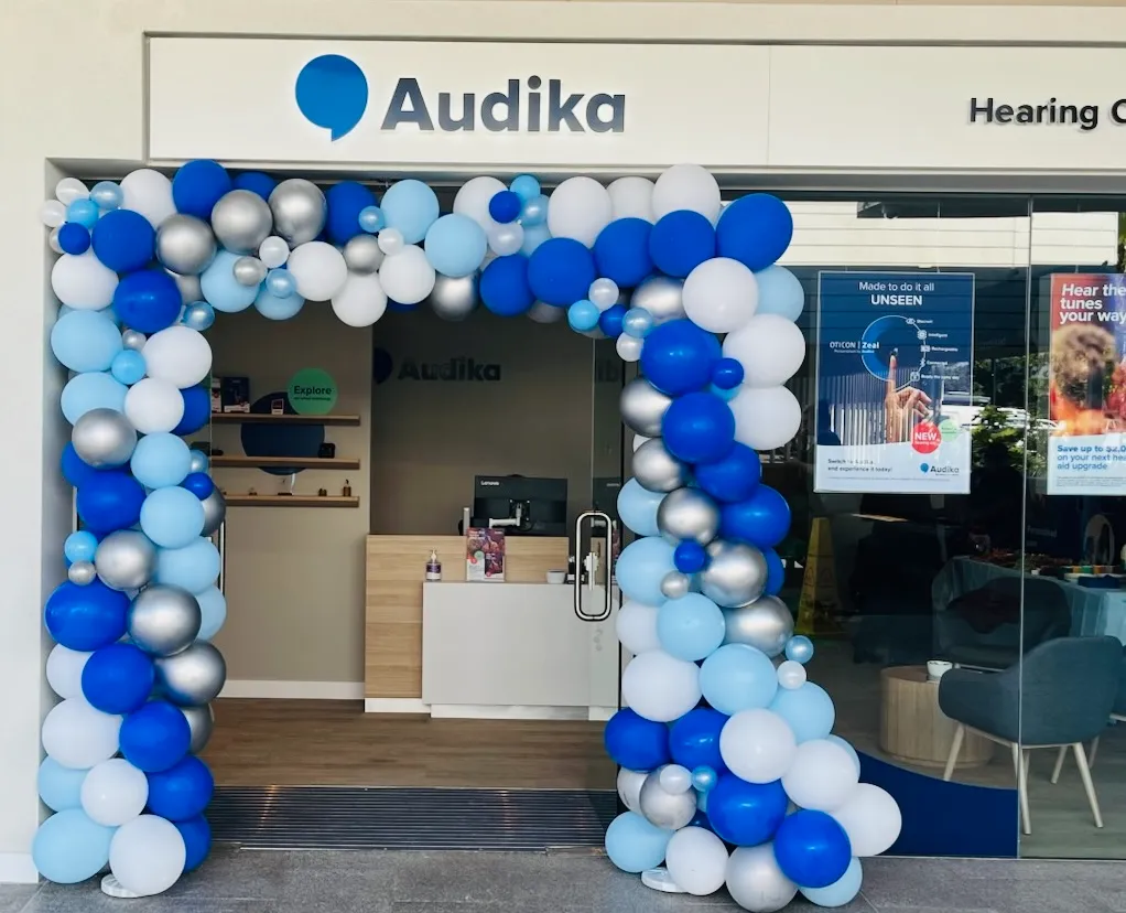 Blue and silver balloon arch built around a business doorway