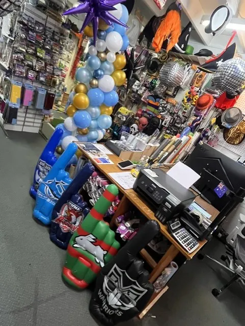 Party supplies display stand with balloons and costume accessories in store