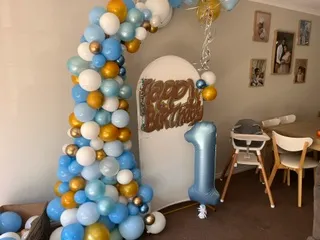 First birthday themed arrangement with a blue and white balloon garland
